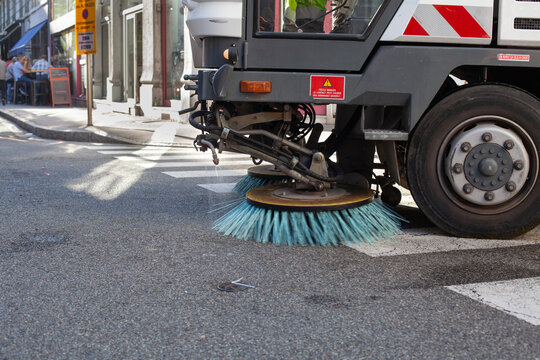 Fototapeta cleaning city street, closeup of brush of a street sweeper vehicle