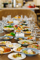 a large served festive table with appetizers. Fruit dish stand in the center of the table.