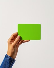 a hand holding a green card