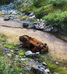 Abandoned crashed off road car at the bottom of a dry river. Danger