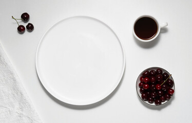 Empty white plate, coffee and cherry on white table