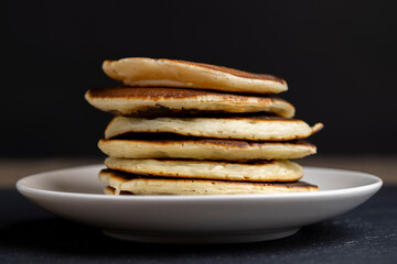 soft fresh pancakes and natural liquid honey in a wooden bowl