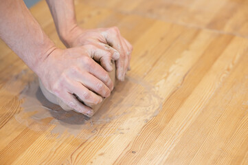 A potter kneads clay before using it in the workshop. Close-up of a man's hands. 