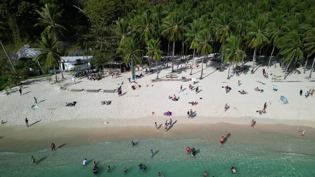 Ascending drone footage of the beachgoers at Seven Commandos Beach in El Nido, Palawan, Philippine