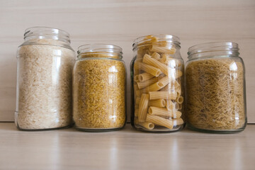 A row of glass jars filled with various types of food.  