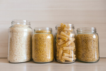 A row of glass jars filled with various types of food. 