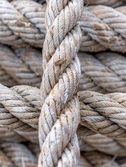 Weathered marine ropes in a port, worn boat line, bulky maritime grimy tattered white ropes backdrop, focused on cords. Detailed design grime Old seafaring ropes.