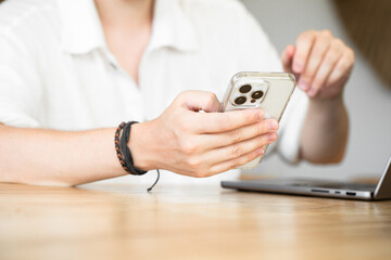 Fototapeta premium Freelancing. A man surfs the Internet, searching for information on the Internet. A man touches the phone screen with his finger. Scroll the web. Communication via smartphone. 