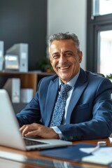 Obraz premium Man sitting at a desk with a laptop computer
