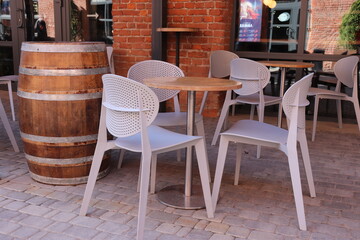 Restaurant veranda. Chairs, table and large wine barrel.