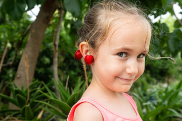 A cherry in the ear of a smiling girl. © TAMER YILMAZ