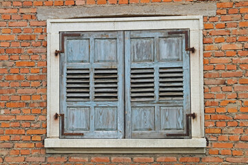old and dilapidated shutters on a brick building with white surrounds