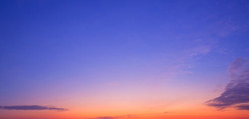 Obraz premium Colorful twilight sky background with dark cloud on beautiful majestic orange and blue evening sky in panoramic view