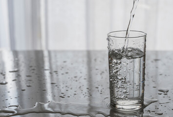 Background image with a glass of water. Pouring water into the glass