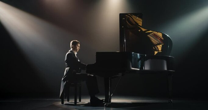 Young Pianist Playing Academic Music, Performing Classical Solo Compositions on a Dark Stage. Grand Piano Resounds With Rich, Melodic Tones of a Romantic Ballad. Pianist Playing Under a Spotlight