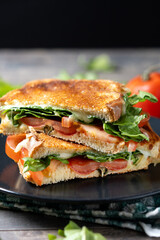 Healthy spinach, tomato and cheese sandwich on wooden table