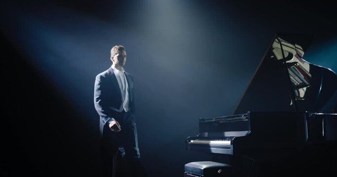 Pianist Standing Center Stage, Acknowledging the Cheerful Ovation With a Grateful Smile. He Bows Gracefully, Hand on Heart, Thanking the Audience for Their Appreciation and Support