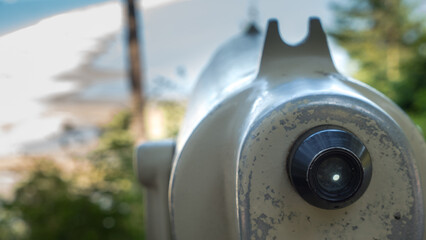 A sightseeing scope lens is pointed at a beach vista