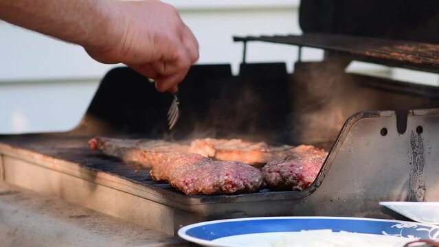 Fli[ping the meat on the grill flaming meat
