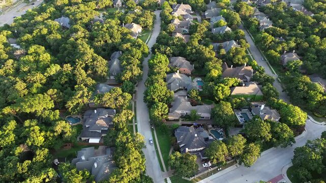 Tree lined residential street in affluent neighborhood near highway in North of Dallas Fort Worth metroplex, expensive suburban mansion houses with swimming pool, solar panel roofing, flyover