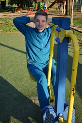 A dedicated young athlete puts in the hard work, vigorously training on gym equipment outdoors to...