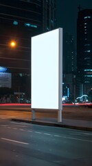 Blank illuminated billboard on a city street at night, perfect for advertisement mockups and promotional designs.