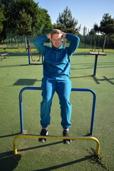 A dedicated young athlete puts in the hard work, vigorously training on gym equipment outdoors to...