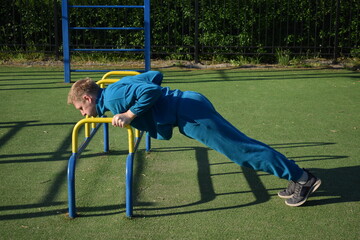 A dedicated young athlete puts in the hard work, vigorously training on gym equipment outdoors to...