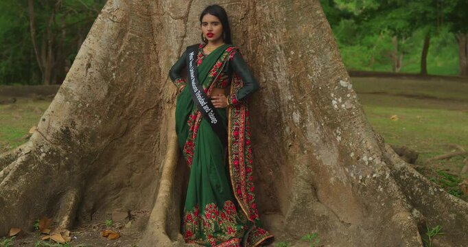 A young girl enjoys a day at a tropical park in the Caribbean, dressed in traditional Indian attire.