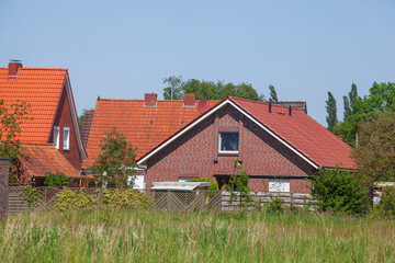 Fototapeta premium Wohngebäude, Einfamilienhäuser aus Backstein im Grünen, Leer, Ostfriesland, Niedersachsen, Deutschland