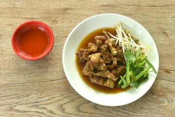 braised pork and fresh vegetable in herb brown soup on dish dipping spicy chili sauce 