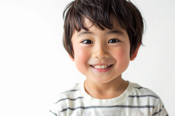 Sweet Japanese preschool-aged boy with a gentle smile, looking at the camera, isolated on white background.
