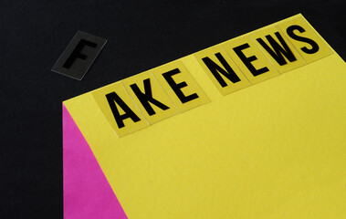 fake news concept, simple optical illusion with 3 sheets of paper and lettering,close up, free copy space