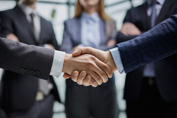 Business colleagues shaking hands in an office hallway