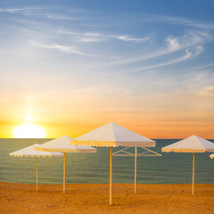 sea beach with sun umbrella at the sunset