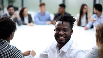 The head of the financial department at the workplace against the background of colleagues