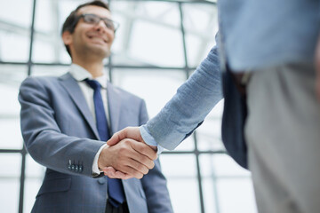 Two business men shaking hands together after successful meeting.