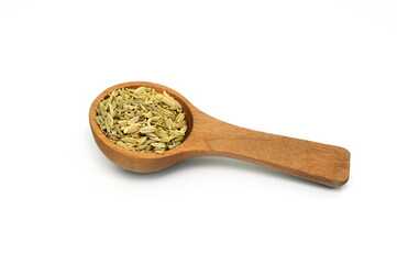 dried fennel seeds in a wooden spoon  isolated on white