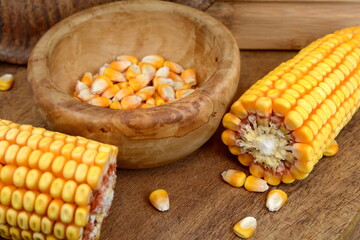Corn cob and seeds on wooden table