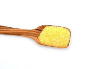 Uncooked cornmeal maize flour heap in a spoon isolated on white background