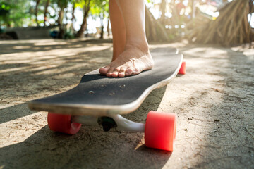 Close-Up of Barefoot Female Foot on Longboard in Beachside Skatepark