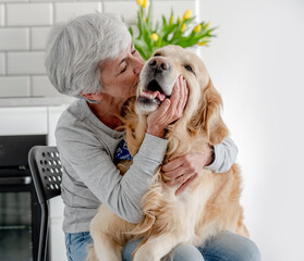 Woman With Grey Hair Enjoys Time At Home With Golden Retriever