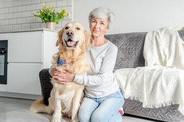 Woman With Grey Hair Enjoys Time At Home With Golden Retriever