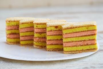 Sliced sponge cake on a white disposable plate on a table