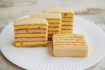 Sliced sponge cake on a white disposable plate on a table close-up