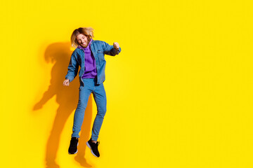 Fototapeta premium Full length portrait of nice young man jump empty space ad wear denim jacket isolated on yellow color background