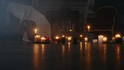 No people stab shot of multiple burning candles on floor in dark smoky house, preparation for mystical ceremony