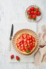 Strawberry tart. Delicious homemade strawberry cake with fresh fruits served and cream cheese on white marble stand and wooden table. Summer berry dessert. Cover or article. Top view copy space.