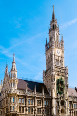 The New Town Hall in Munich showcases beautiful Gothic architecture against a backdrop of a clear blue sky