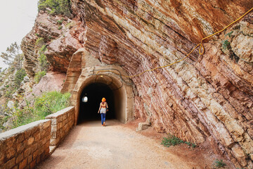 Traveler exploring a mountain track with a tunnel entrance on the coastline of Petrovac, Montenegro